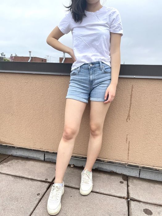 A writer in shorts and a white t-shirt standing on a rooftop.