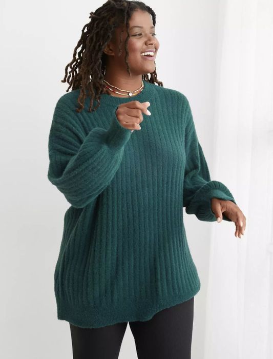 The model is wearing the teal sweater.