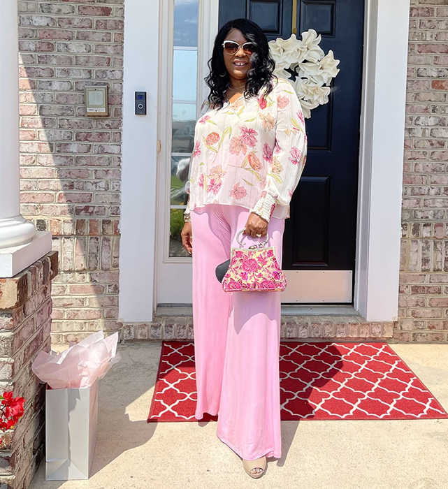 A reviewer is shown wearing pink palazzo pants, photographed on a front porch.