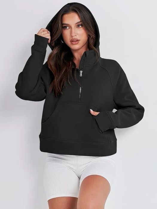 A woman in a black hoodie and white shorts striking a fashion pose, ideal for a shopping feature