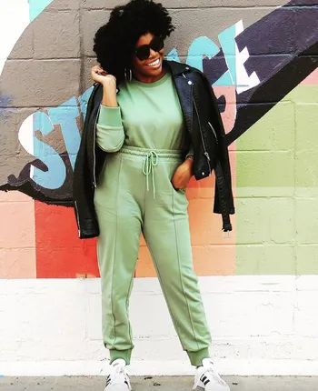 a reviewer wearing a matching green sweatshirt and pants