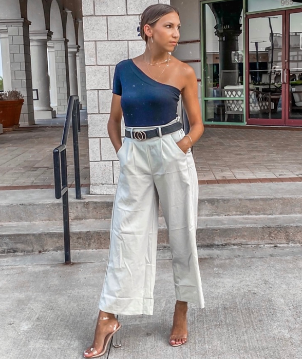 A reviewer is seen wearing the beige pants, having replaced the tie belt with their own.