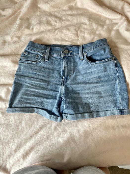 A photo of shorts laid out on a bed.