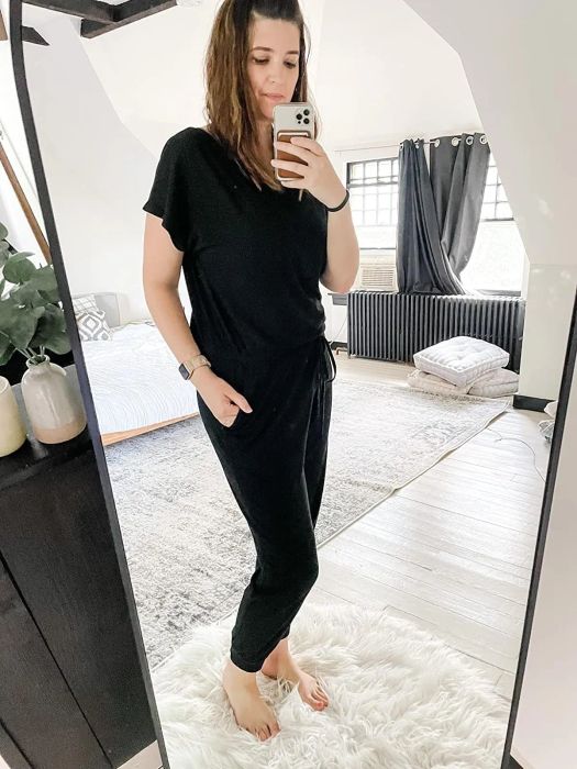 A person taking a mirror selfie in a black casual outfit with a tied waist, perfect for fashion-focused shopping content
