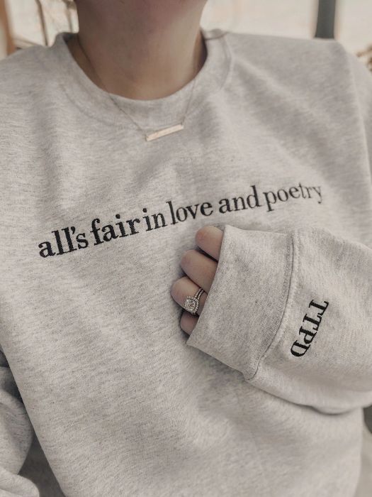 A person wearing a sweater with the phrase 