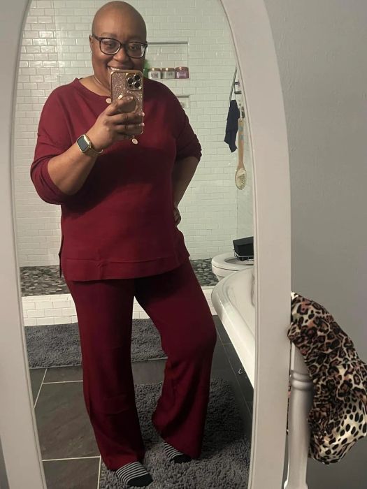 A person taking a mirror selfie in a casual red top and pants outfit, perfect for a shopping-inspired article