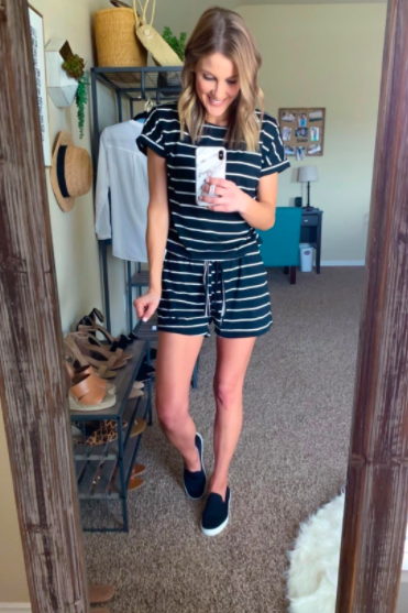 A reviewer styling the black and white striped romper with casual slip-on sneakers