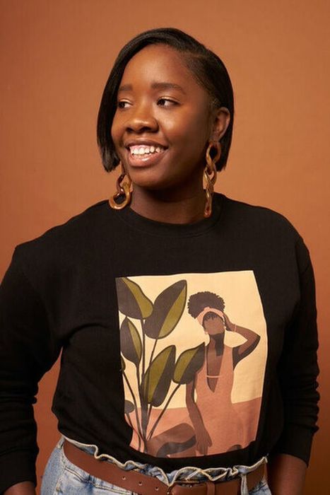 model sporting a black crewneck sweatshirt with a graphic design