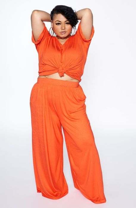 A model wearing the orange pants paired with a matching tee