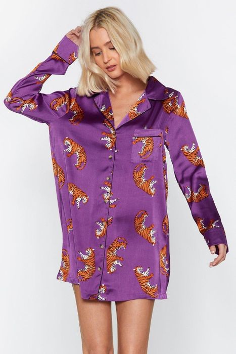 The model is wearing a purple satin shirt with a bold leopard print design.