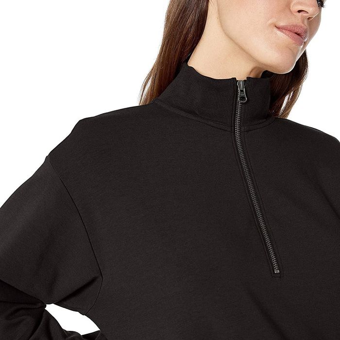 The model is wearing a classic black sweater.