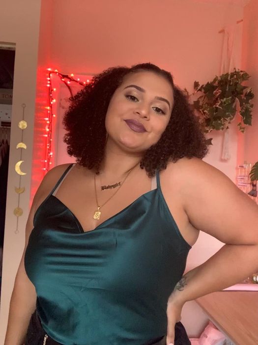 Reviewer modeling the top in a deep green hue