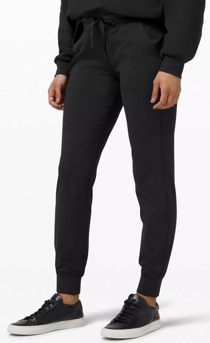 front view of model wearing black cinched joggers with a drawstring waist