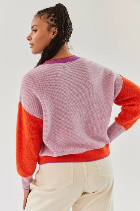 Back view of model wearing the pink and red color-blocked sweater