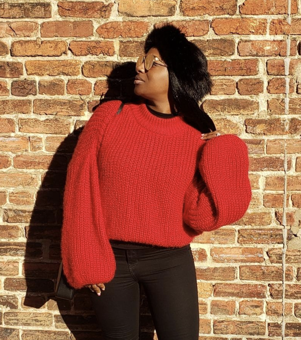 A reviewer sporting the red sweater, showcasing its style and comfort.