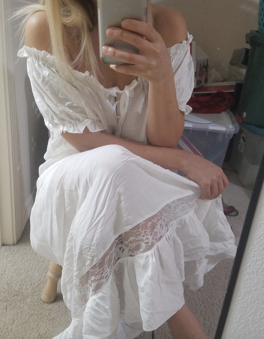 The reviewer is dressed in the same white dress.