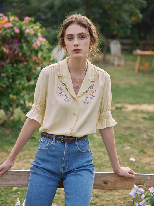 a model wearing the blouse in a vibrant yellow