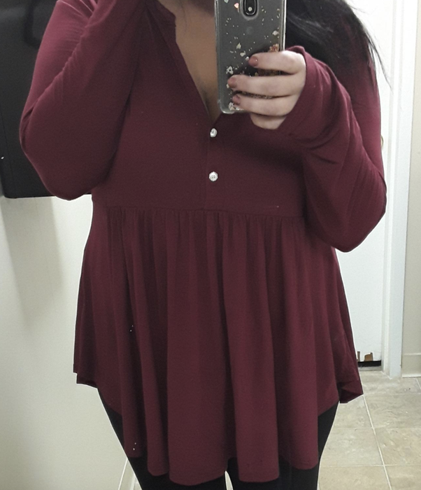 The reviewer is dressed in a red top.