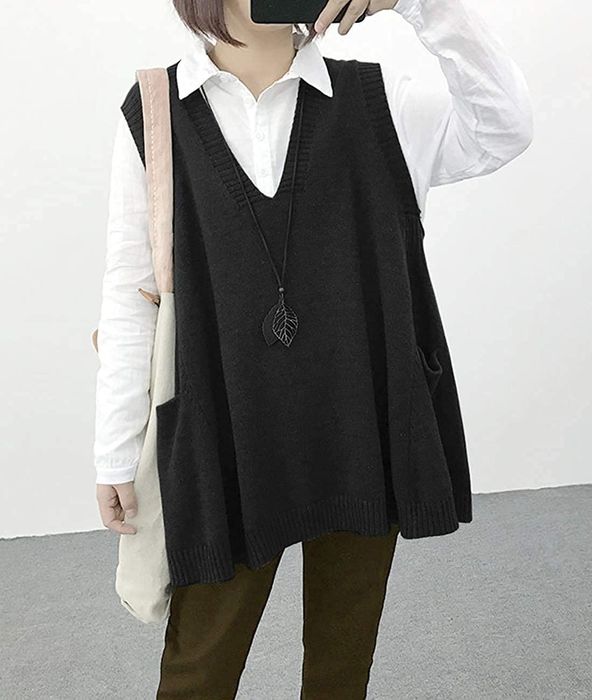The model is styled in an oversized gray sweater vest layered over a crisp white button-down.