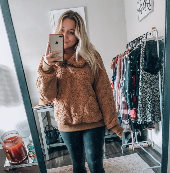 The reviewer is showcasing the taupe sweater.