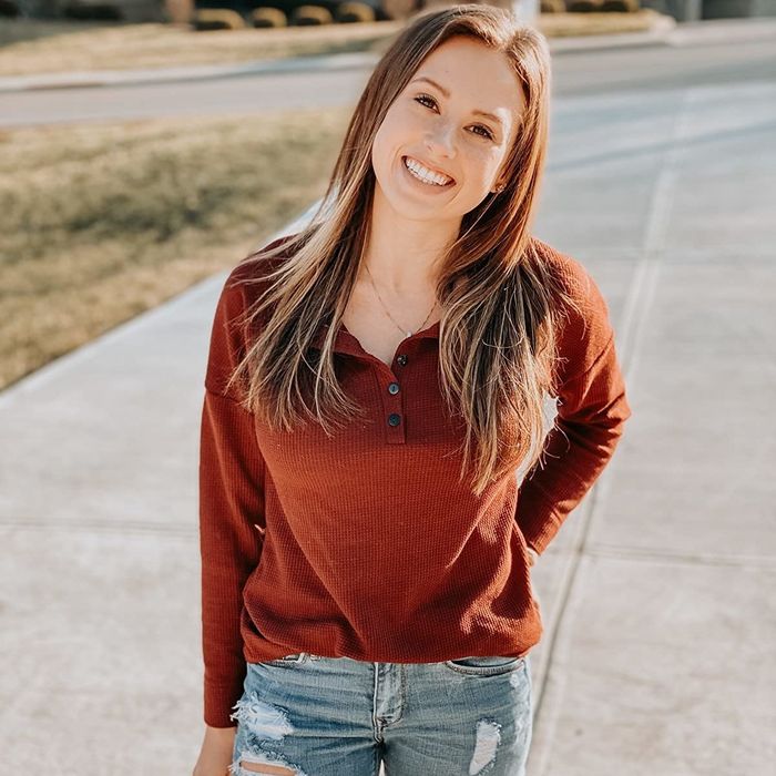 The reviewer is seen wearing a red Henley shirt.