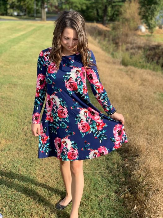 Reviewer wearing a navy blue floral T-shirt dress