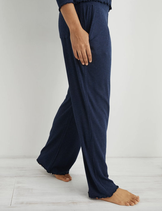 The model is wearing wide-leg navy sleep pants.