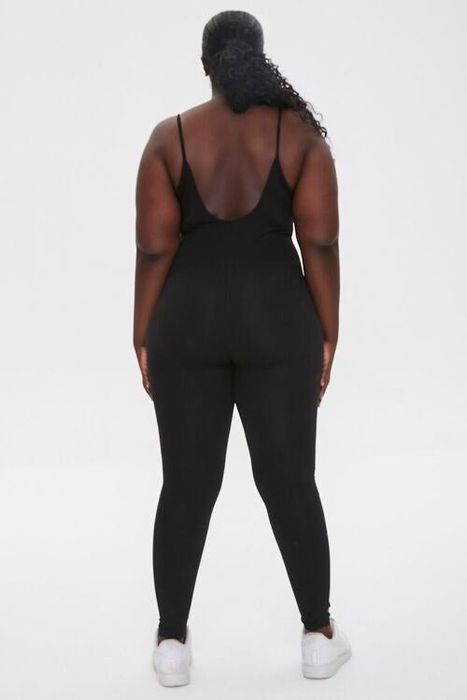 The model is wearing a black open-back jumpsuit.
