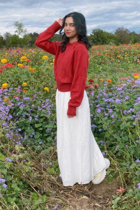 The sweater is showcased in a vibrant red color.