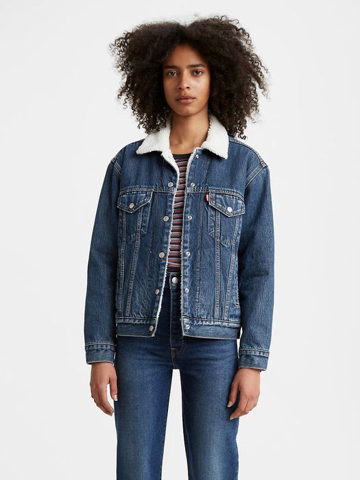A model wearing the medium wash jacket that falls at hip length