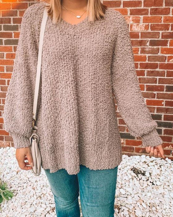 A close-up shot shows the reviewer wearing the khaki-colored popcorn sweater.