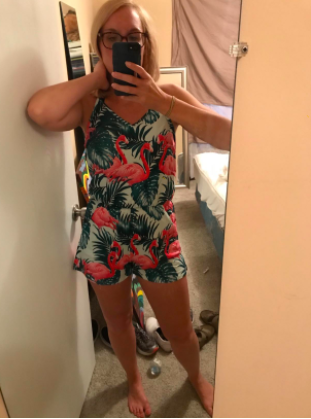 A reviewer wearing the romper with a flamingos and leaves print