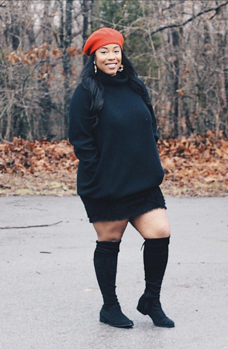 A reviewer showcasing the black dress in a stylish setting