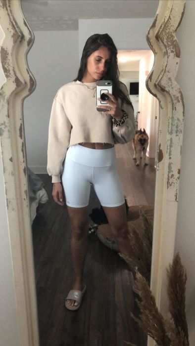 A beige cropped pullover paired with white biker shorts—a perfect combination for an effortlessly chic look.