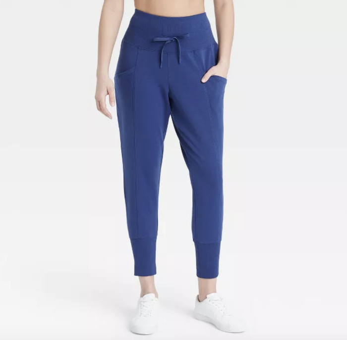 The model is wearing royal blue high-waisted joggers.