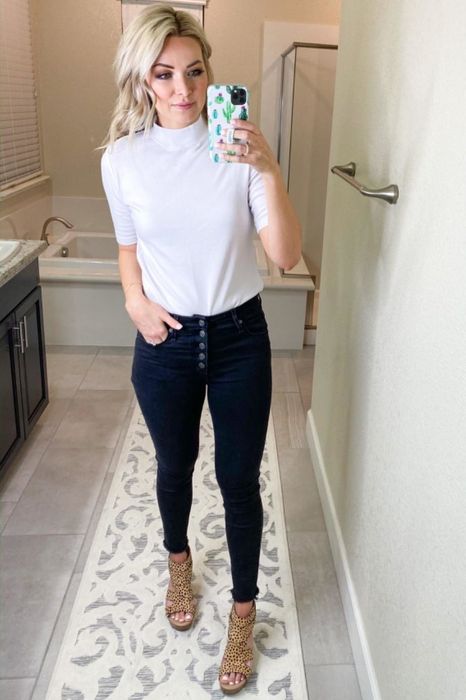 A reviewer is seen in a white mock turtleneck sweater.