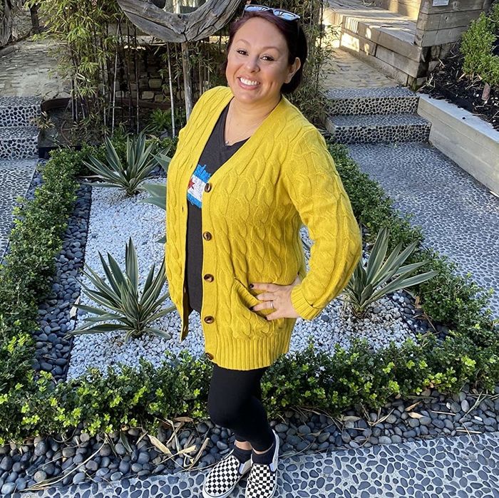 A reviewer is seen wearing a yellow cardigan.