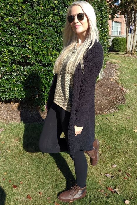 The reviewer is styled in a long black cardigan.