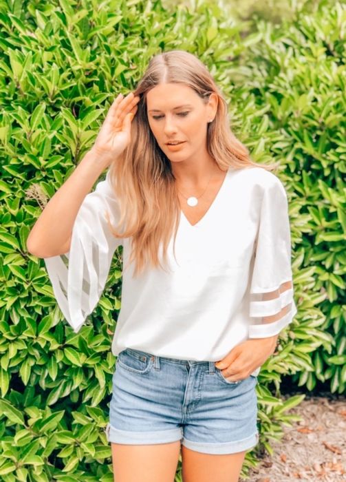 a model wearing the white top