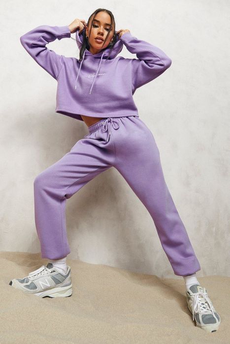 The model is dressed in a pair of purple joggers.