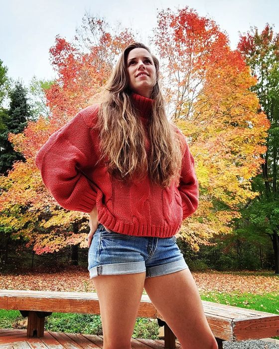 A reviewer styling the red turtleneck with casual denim shorts.