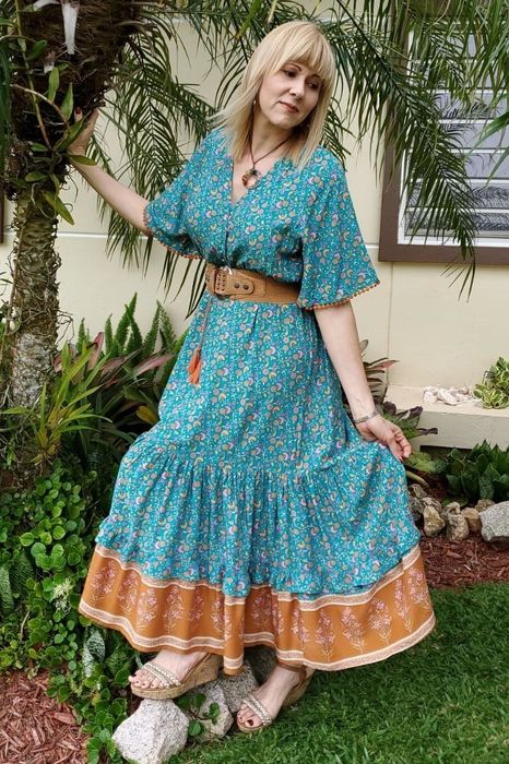 Reviewer styled in a green patterned dress by R.Vivimos