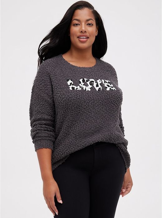 The model is wearing the gray Love sweater, slightly tucked into a pair of black jeans.