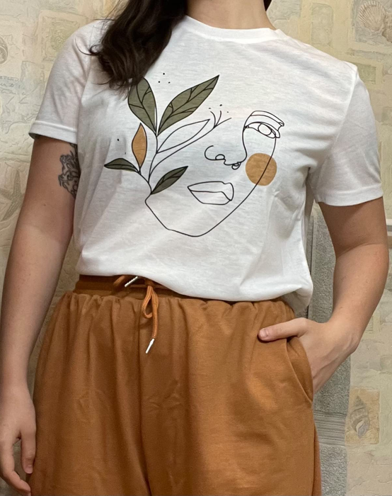 a reviewer wearing a white t-shirt featuring a hand-drawn portrait design