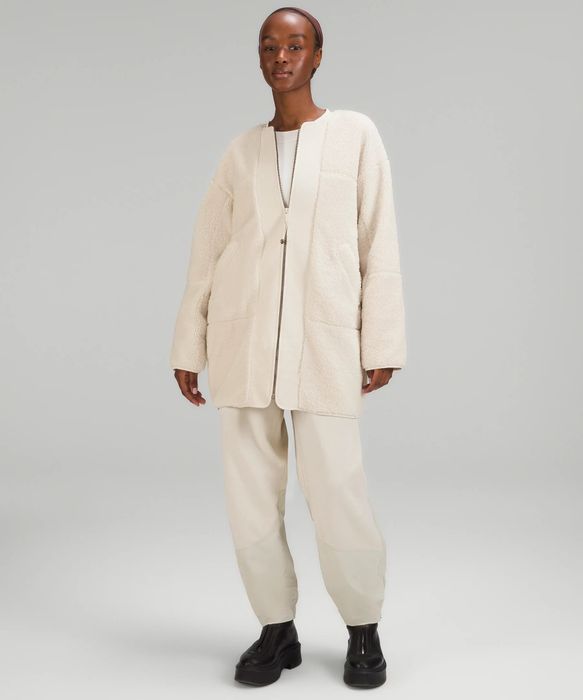 A model showcases the cream-colored fleece zip-up, proving that comfort and style can go hand in hand.