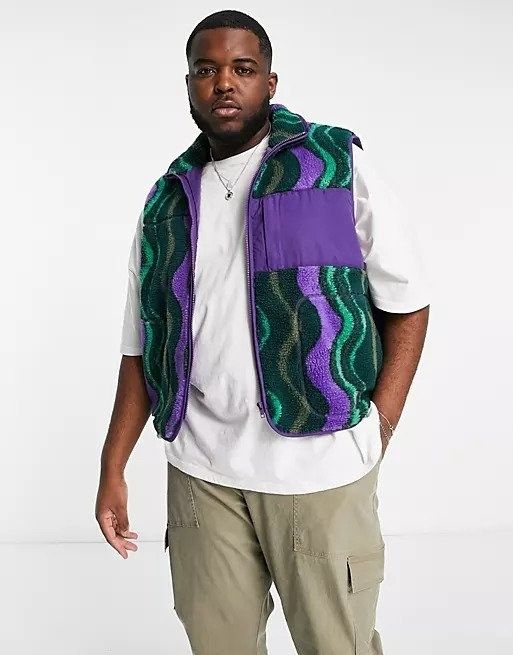 Model wearing a green and purple wavy patterned teddy vest over a white tee