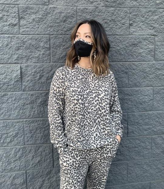 A model wearing the leopard print sweatshirt with matching sweatpants