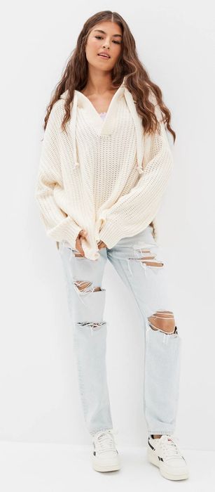 The model is wearing a white oversized hoodie sweater.