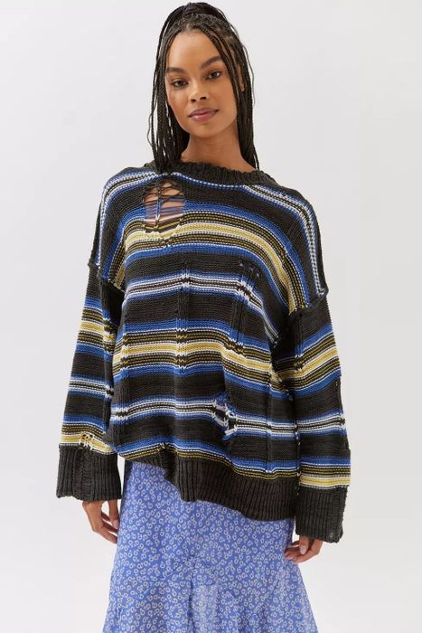 Model wearing a blue and yellow striped distressed sweater