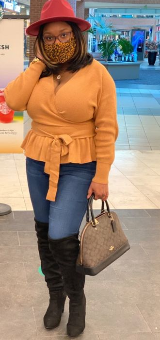 A customer review photo featuring the sweater in a vibrant orange hue